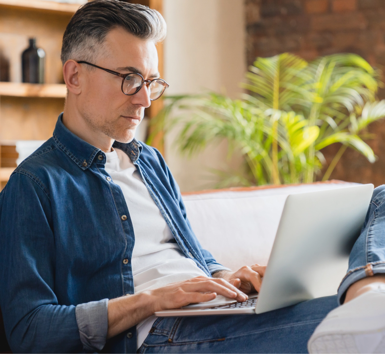 man on a sofa with a laptop