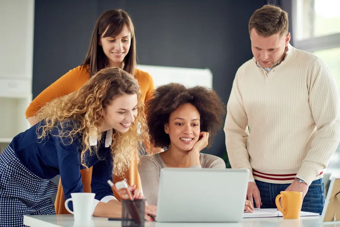 4 people in front of a laptop