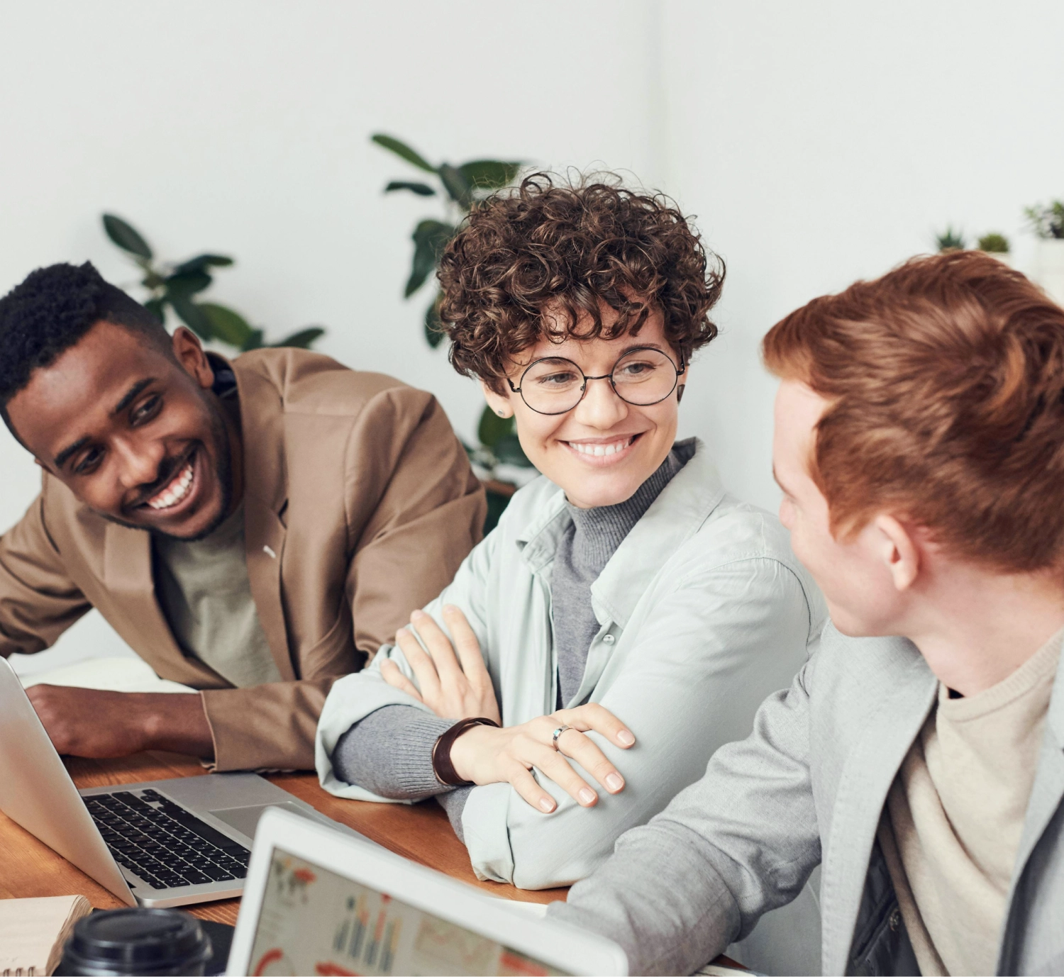 people at a desk in front of a laptop